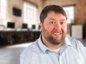 Joe - portrait of man wearing a light patterend shirt and beard